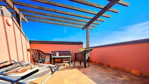 A rooftop terrace with a pergola, a table with chairs, and a sun lounger. - ALBERGO B&B TENESI (Manerba del Garda)