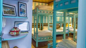 Bunk beds with a shelf displaying framed photos and decorative items.