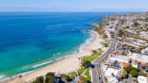 Vista aérea de una ciudad costera con playa, carreteras y edificios.