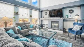 Un salón amplio con chimenea, televisor grande y asientos cómodos.