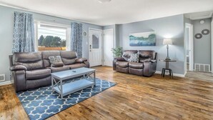 A living room with two leather sofas, a coffee table, and a patterned rug.