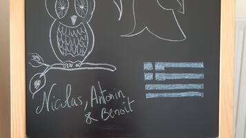 A chalkboard with drawings of an owl and a helmet, and names written below.