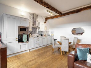 A kitchen with white cabinets, a built-in oven, and a herringbone-patterned backsplash. - Blists Hill Barn Conversion (Madeley)