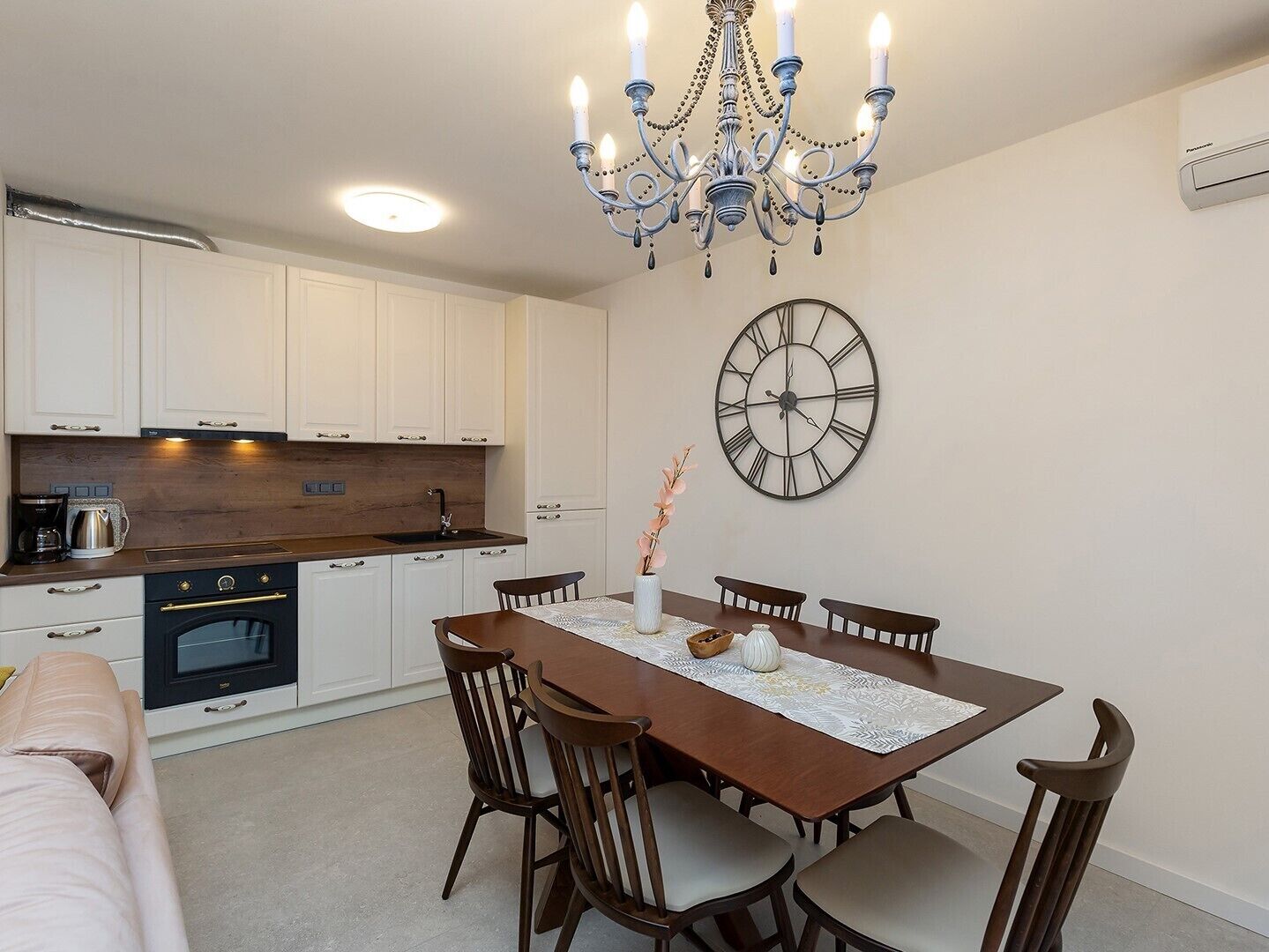 A modern kitchen with white cabinets, a wooden countertop, and a built-in oven.