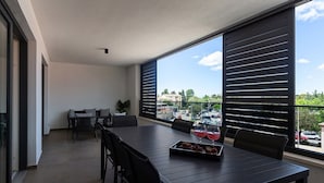 A balcony with a dining table, chairs, and a tray of fruit. - Apartment with Balcony No.18 in Nar Residence (Porec)