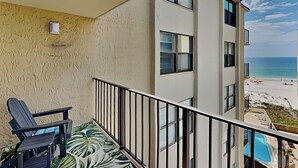 Un balcone con una sedia e vista sulla spiaggia e sull'oceano.