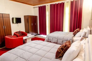 A hotel room with two beds, a red armchair, a TV, and wooden wardrobes. - EZRA BOUTIQUE HOTEL by The Weekender (Kigali)