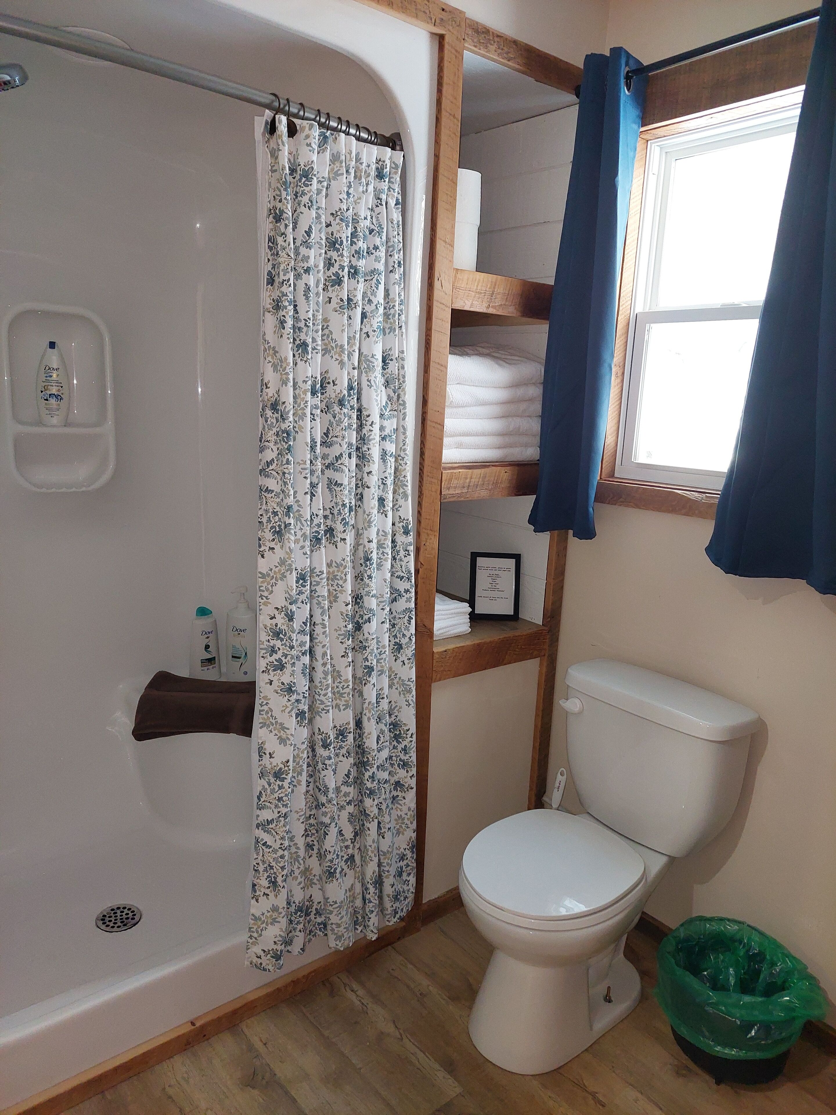 Un bagno con doccia, toilette e un ripiano con articoli da toilette.