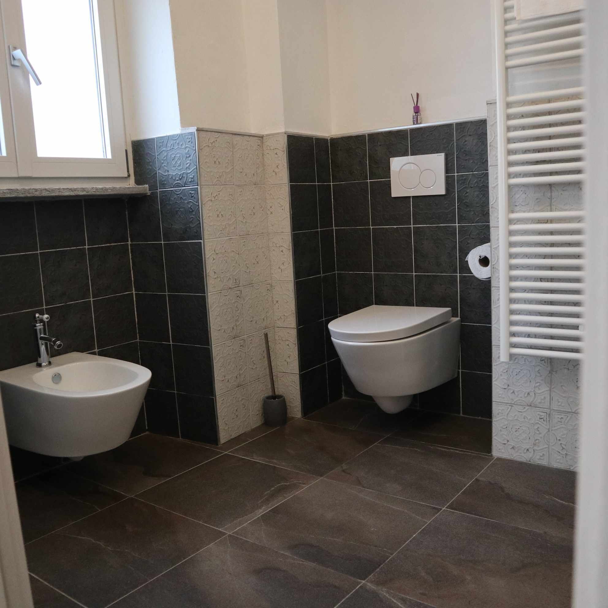 Een badkamer met een wastafel, toilet en raam.