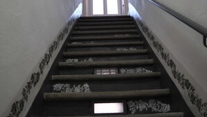 Eine Treppe mit floralen Mustern an Wänden und Geländern.