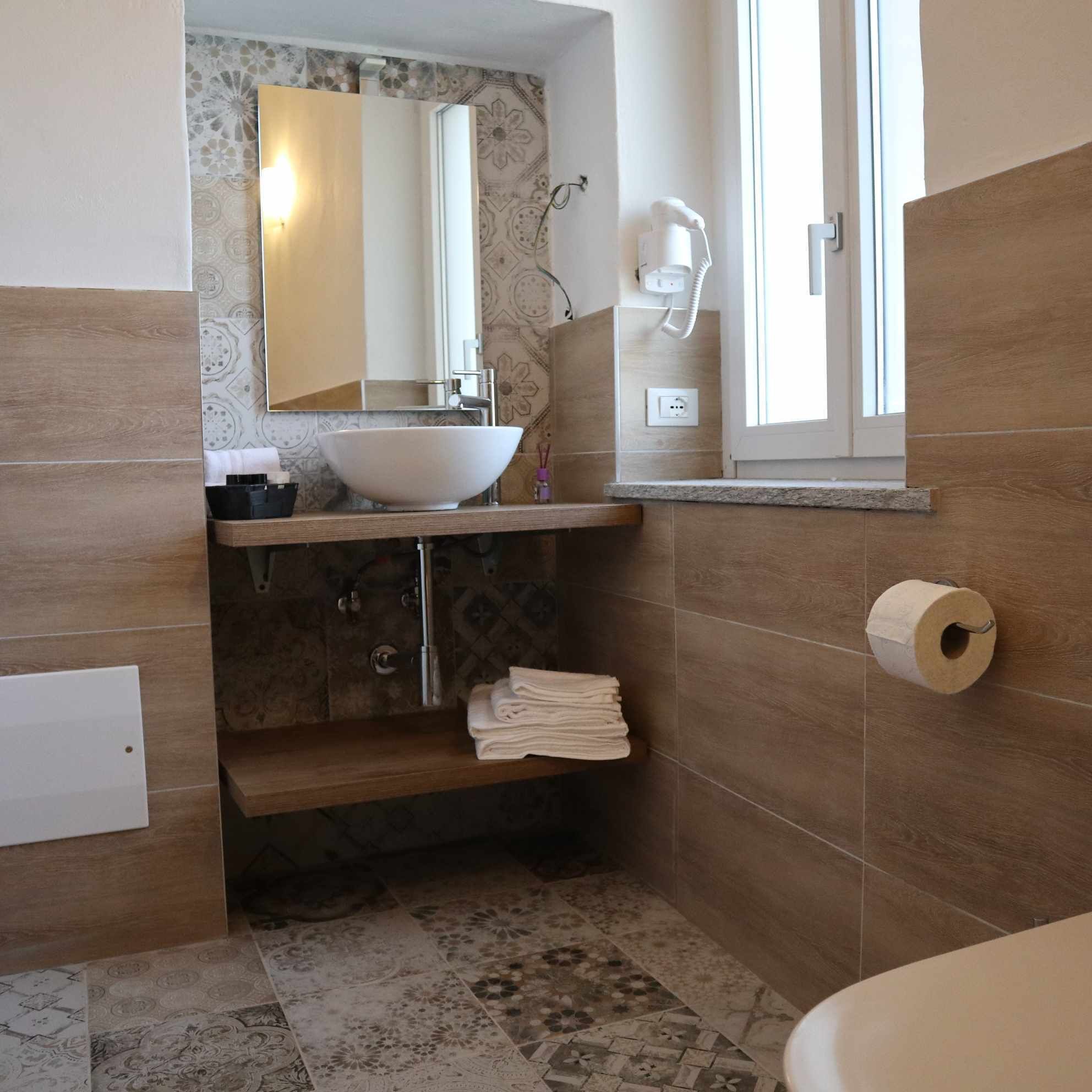 A bathroom with a large sink, a mirror, a towel rack, and a toilet.