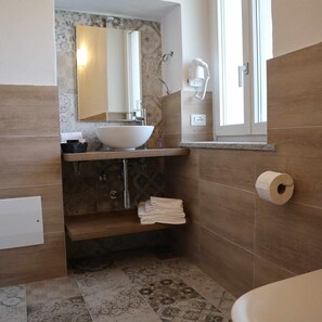 A bathroom with a large sink, a mirror, a towel rack, and a toilet. - Junior suite (Recetto)