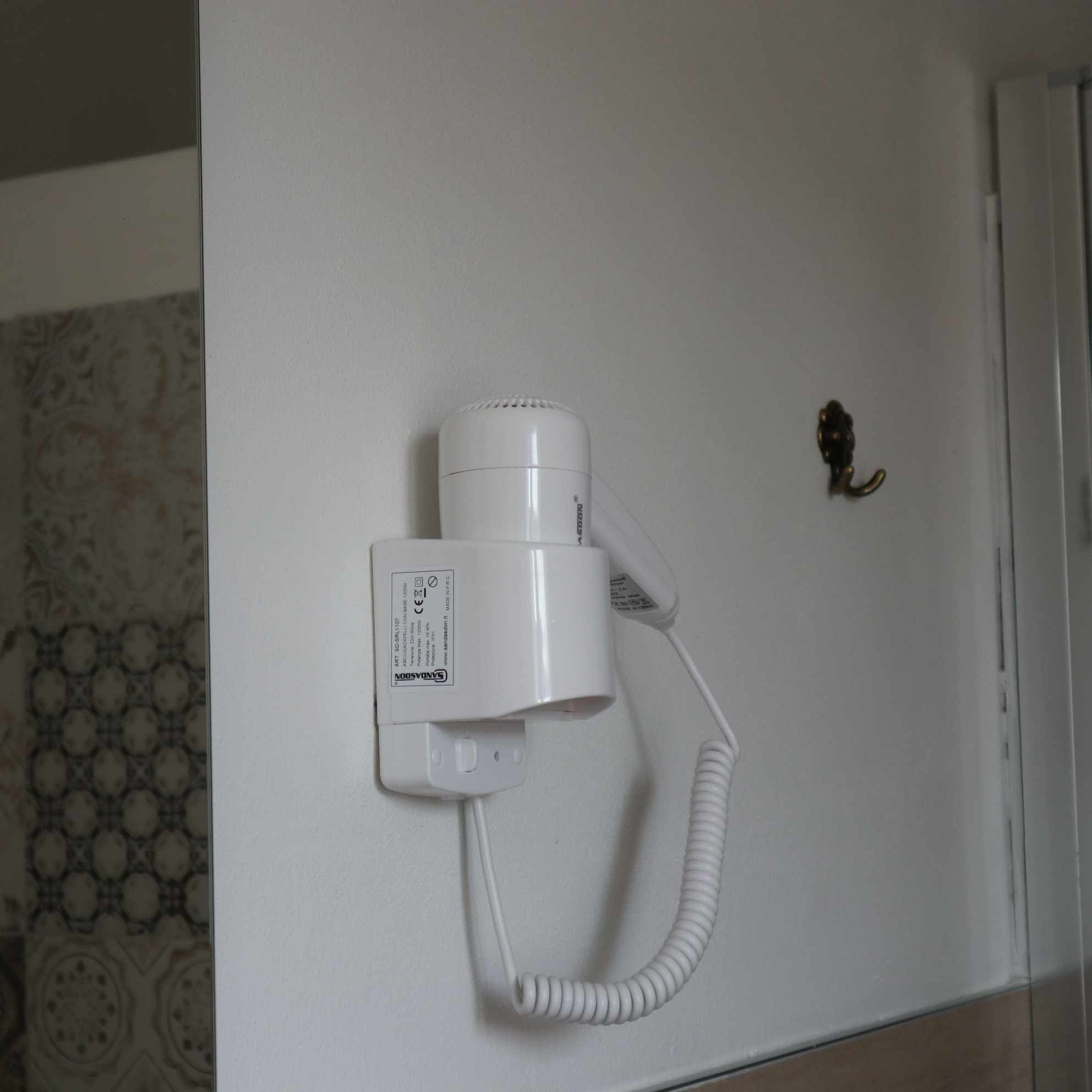 Um secador de cabelo fixado na parede com um cabo.