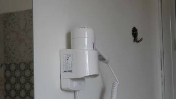 Um secador de cabelo fixado na parede com um cabo.