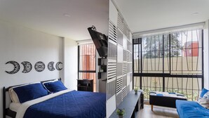 A bedroom with a large bed, a sofa, a TV, and a balcony with a view. - Loft, Historic Center, Bogotá (Bogotá)