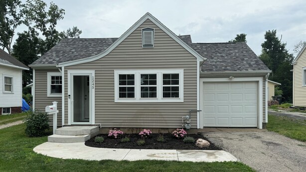 A single-story house with a garage, a front door, and a mailbox. - Newly Renovated Charming Cottage, Occupancy 4   (Cedar Rapids)