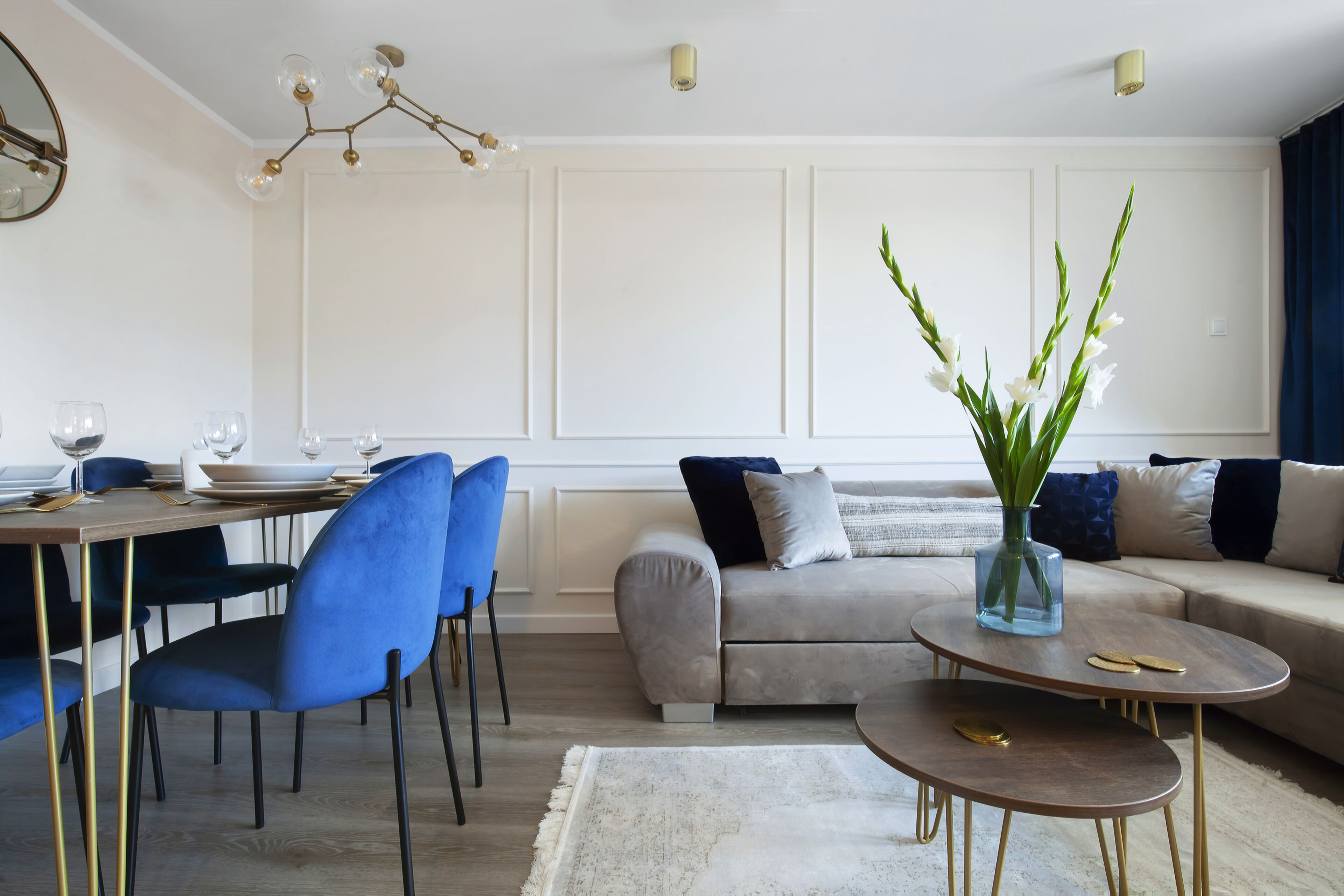 A modern living room with a dining area, a sofa, and a coffee table.