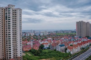 A residential area with high-rise buildings and houses, a road, and a cloudy sky. - Hailai Inn (Beihai)