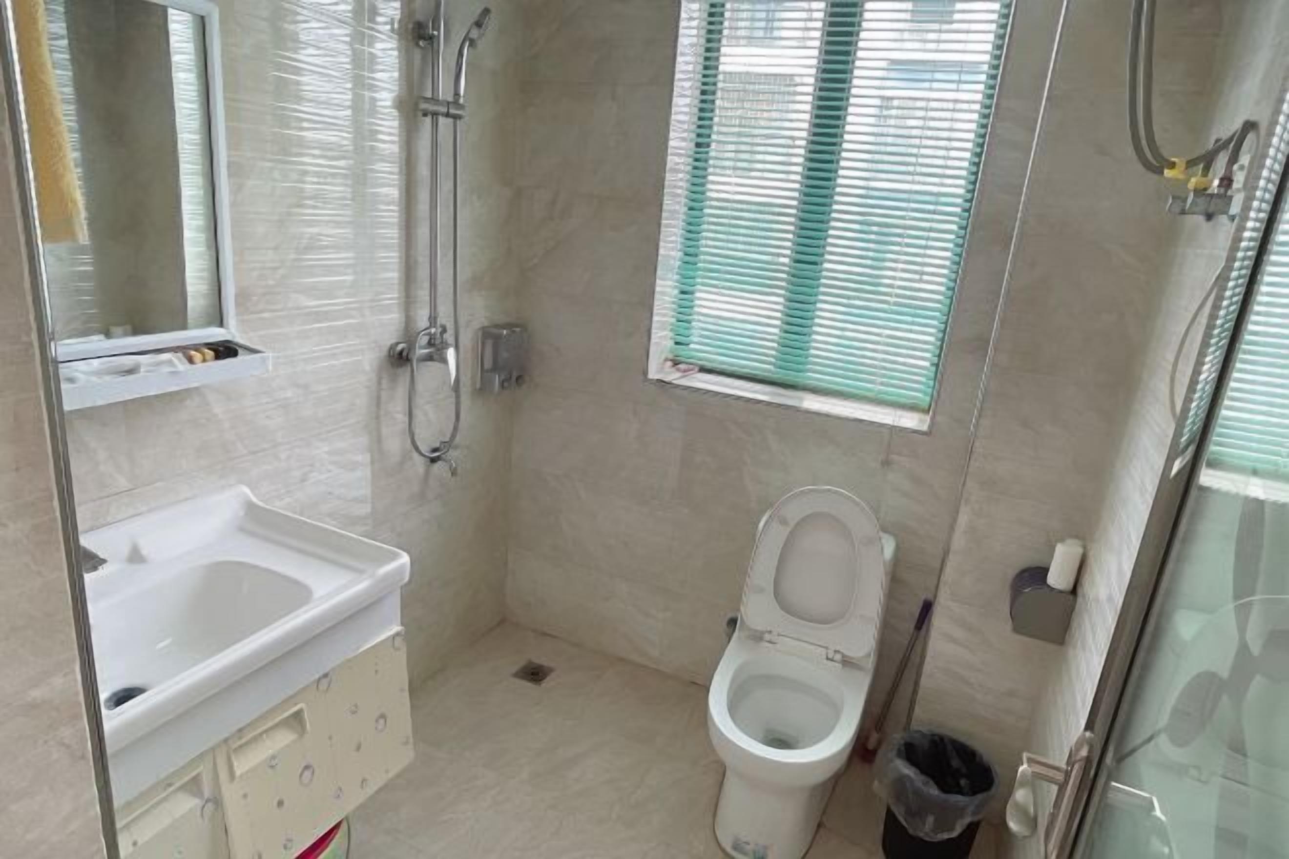 A small, compact bathroom with a toilet, sink, and shower.