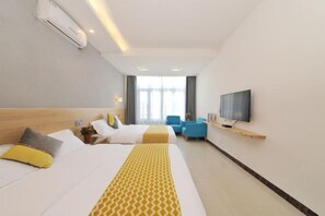 Habitación de hotel con dos camas, un televisor, un escritorio y una silla.