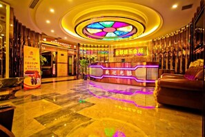A hotel lobby with a reception desk, a seating area, and a decorative ceiling. - Jindu Hotel (Youyang County)