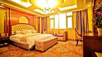 Una habitación de hotel con una cama grande, un escritorio y una silla.