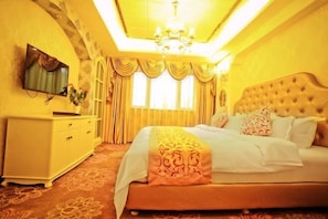 Un dormitorio con cama, cómoda, televisor y candelabro.