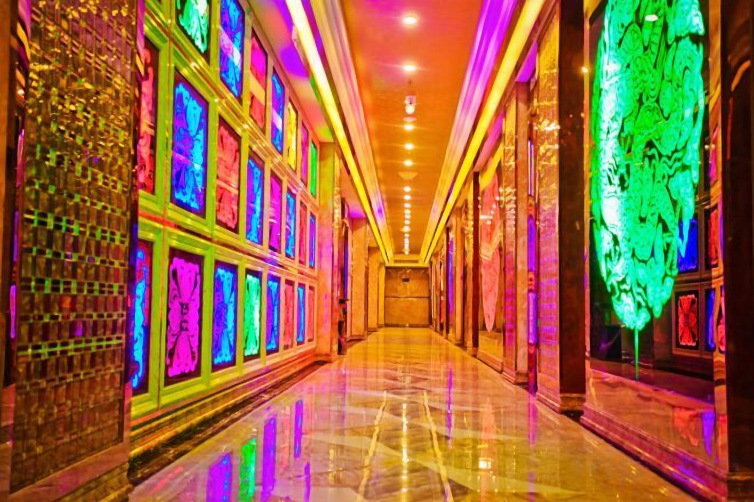 A brightly lit corridor with reflective flooring and patterned walls.
