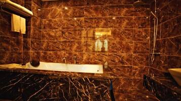 A bathroom with a marble sink, a bathtub, and a shower.