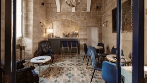A cozy room with stone walls, a bar area, and a mix of classic and modern furniture. - Palazzo Castagna (Ghaxaq)
