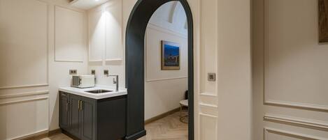 A modern kitchen with dark cabinetry, a white countertop, and a built-in oven.