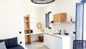 A compact living space with a kitchenette, a sofa, a dining table, and a chair. - Luxury hospitality, outstanding view (Thira - Santorini)
