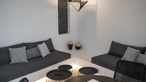 A modern living room with a sofa set, two side tables, and a coffee table. - Luxury hospitality, outstanding view (Thira - Santorini)