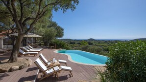 A pool area with lounge chairs and a view of the landscape. - Villa S'Ollastu - Luxury villa with private pool, garden, sea view, near beaches (Chia)