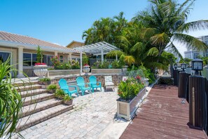 A patio area with outdoor seating, a pergola, and a wooden deck.
