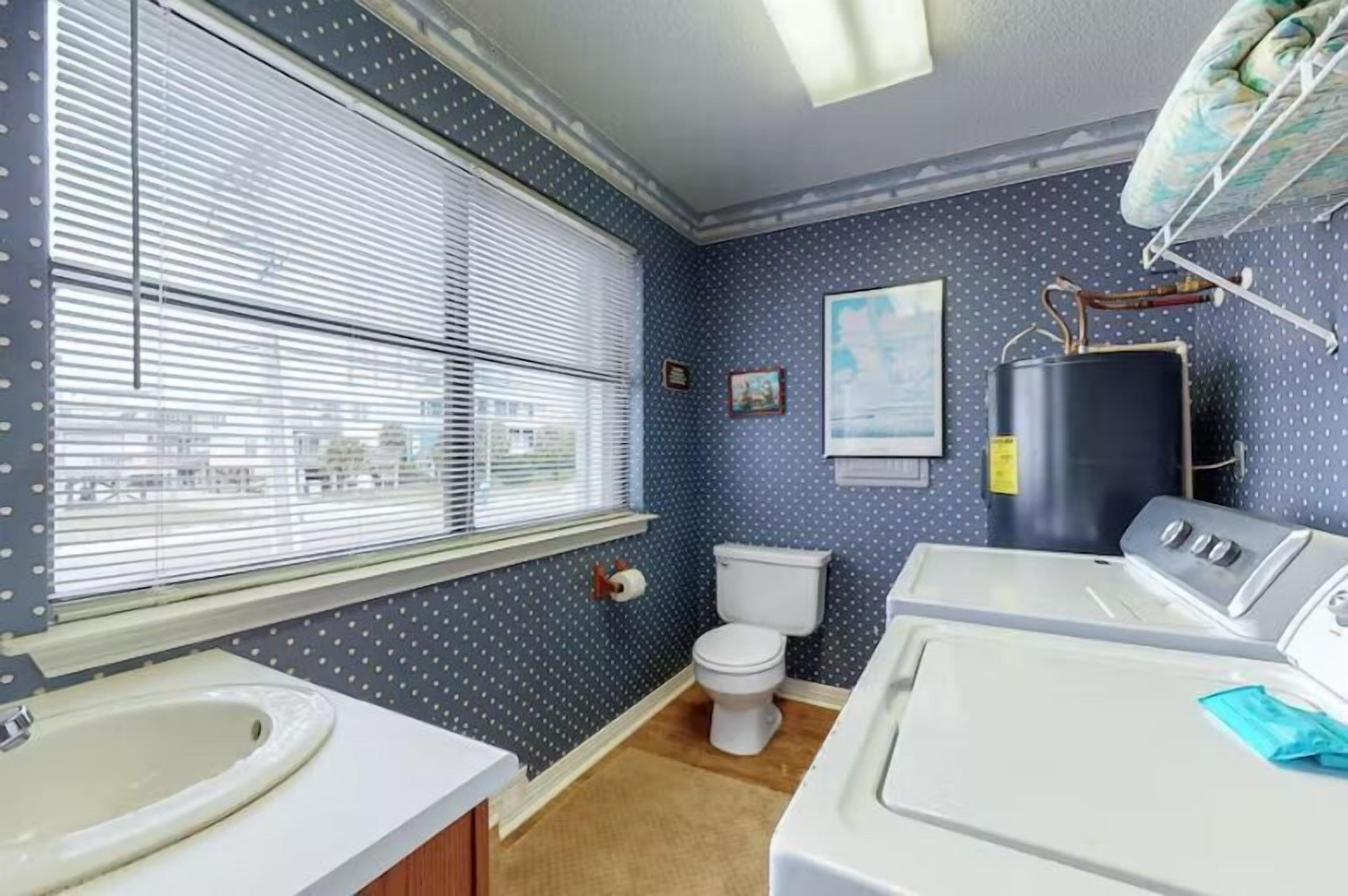 Une salle de bain équipée de toilettes, d’un lavabo et d’un lave-linge.
