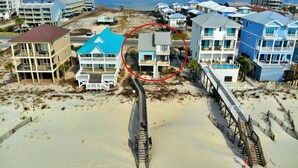 A beachfront property with multiple-story buildings, a sandy beach, and a pier. - Beachfront - Great Location! (Gulf Shores)