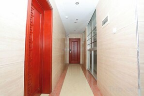 A corridor with a red door on the left and a glass door on the right. - Jindiya Hotel (Fangchenggang)