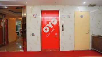 A hotel lobby with a red door labeled 'OYO' and a beige door.