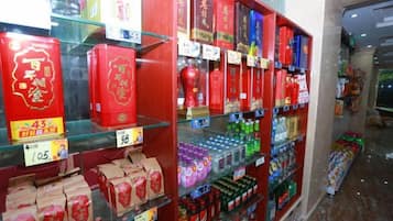 A store interior with shelves stocked with various products, including boxes and bottles, and price tags visible.