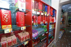 A store interior with shelves stocked with various products, including boxes and bottles, and price tags visible. - Jindiya Hotel (Fangchenggang)