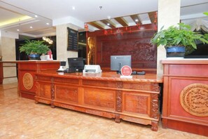 Taulell de recepció amb un ordinador, una impressora i una planta.