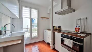 Een oven, een koffiezetapparaat/waterkoker, kookgerei, borden en bestek