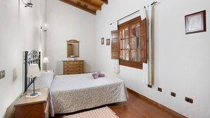 A bedroom with a bed, bedside table, lamp, dresser, mirror, window with curtains, and wall-mounted light fixtures. - Vacation Apartment 'Finca La Bonita Ap P1' with Shared Pool, Shared Terrace and Wi-Fi (Arona)