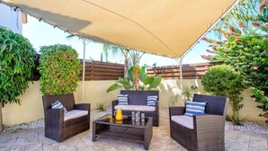An outdoor patio area with wicker furniture, a table, and a canopy. - Villa Sophia - 3 bed villa with private pool, 2 min walk to beach and internet (Paralimni)