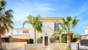 A two-story house with a stone facade, a tiled roof, and a front entrance with a wooden door. - Villa Sophia - 3 bed villa with private pool, 2 min walk to beach and internet (Paralimni)
