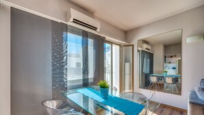A modern dining area with a glass table, clear chairs, and a blue table runner. - Chic Designer Apartment with Sea Views, Wi-Fi and Air Conditioning (Marbella)