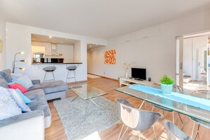 Un salon moderne avec un canapé, une table basse en verre et un téléviseur.