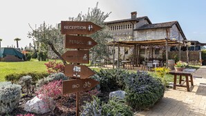 Un panneau indicateur à l’entrée, indiquant la direction de la réception, de la pergola, de la piscine et du parking à vélos.