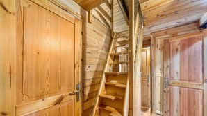 Un intérieur en bois avec un escalier, des portes en bois et un plafond en bois.